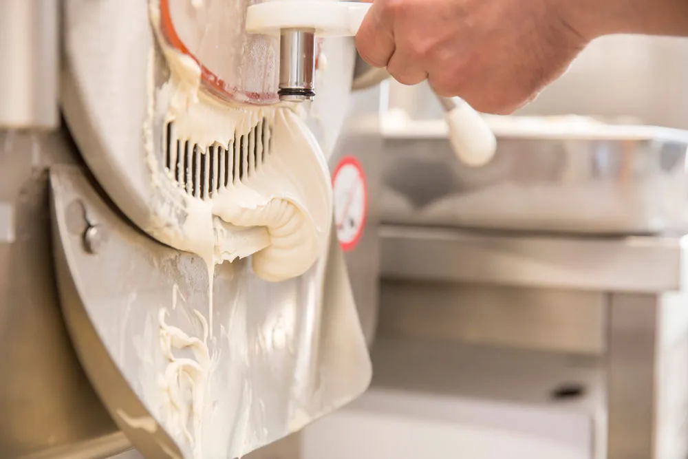 Cremiges Milcheis läuft aus der Eismaschine