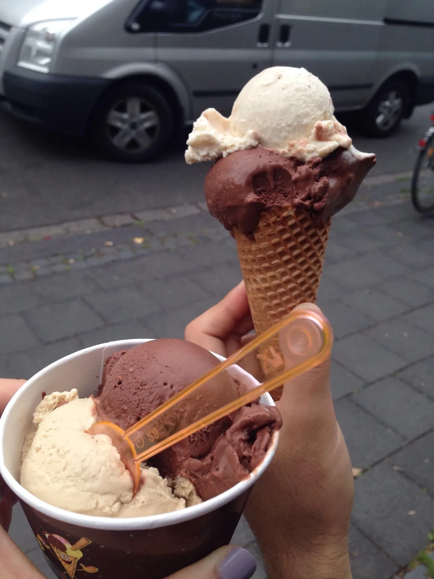 Waffelhörnchen und Becher mit Schokoladen- und Nusseis